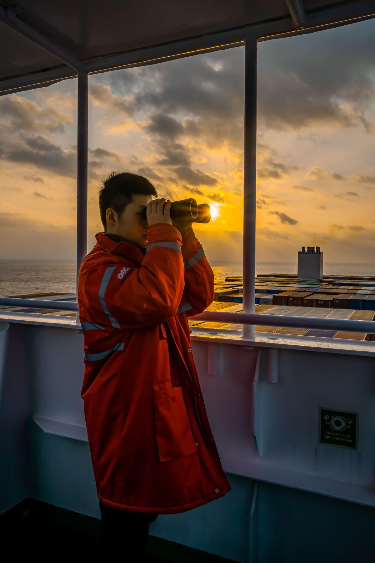 Ship's officer on watch using binoculars at sea